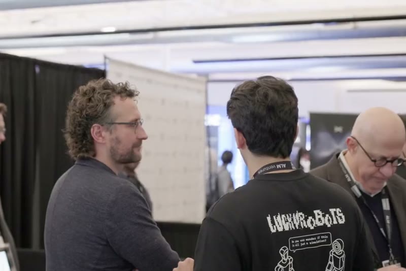 Attendees talking near the exhibit booths at the Humanoids Summit