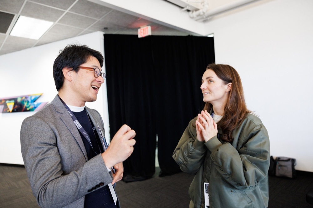 Two attendees mid-conversation, laughing