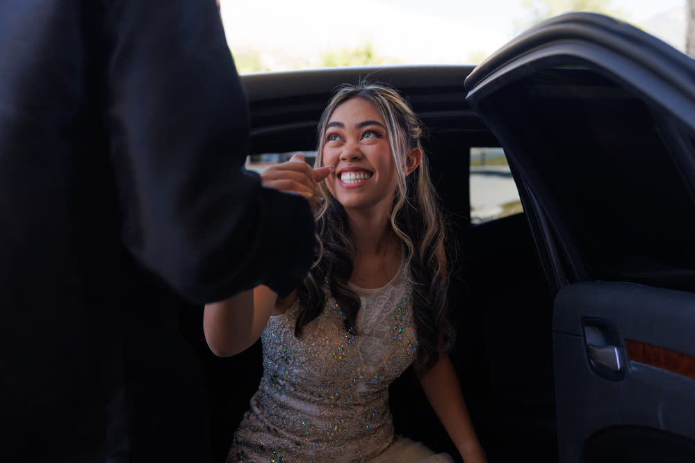 The debutante smiling as she steps out of a limousine