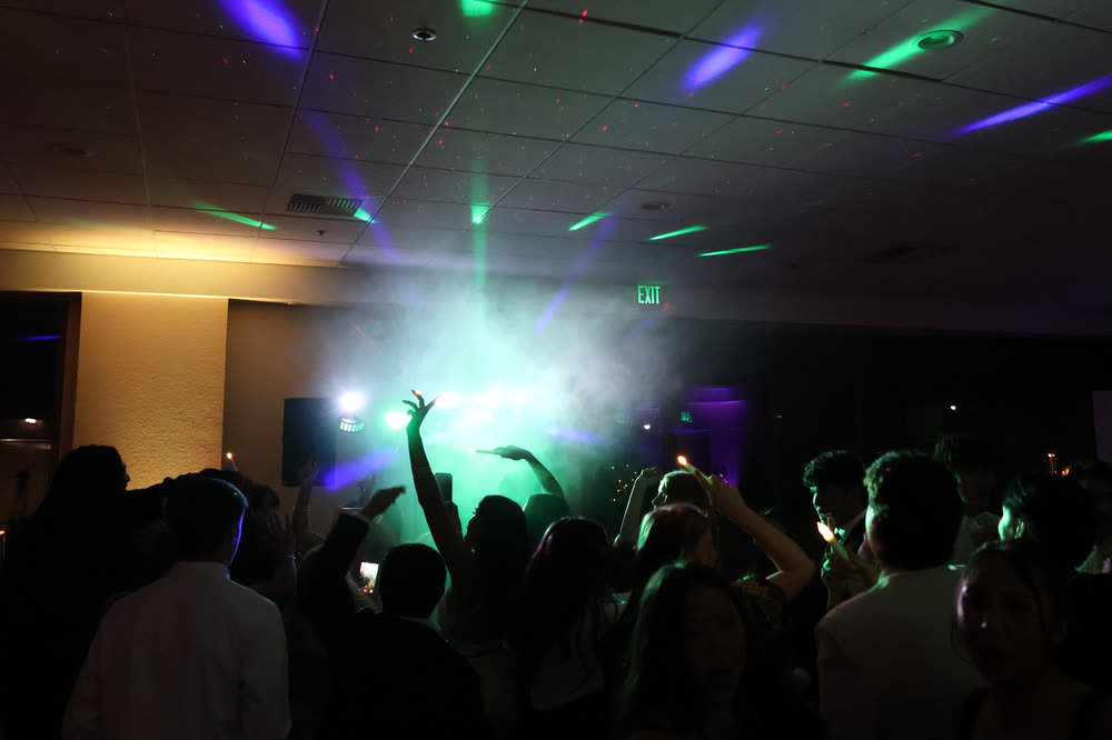 Guests dancing under colored party lights
