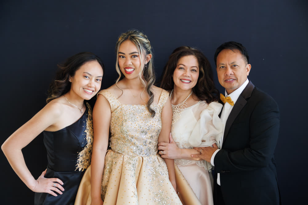 The debutante with her family in front of a dark backdrop