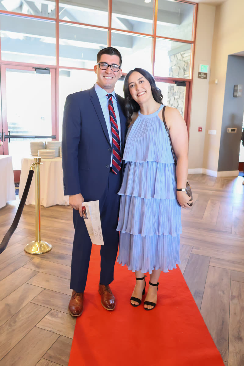 A couple posing on the red carpet at the entrance
