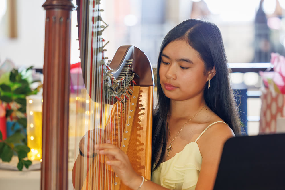 A young harpist playing during a debut celebration
