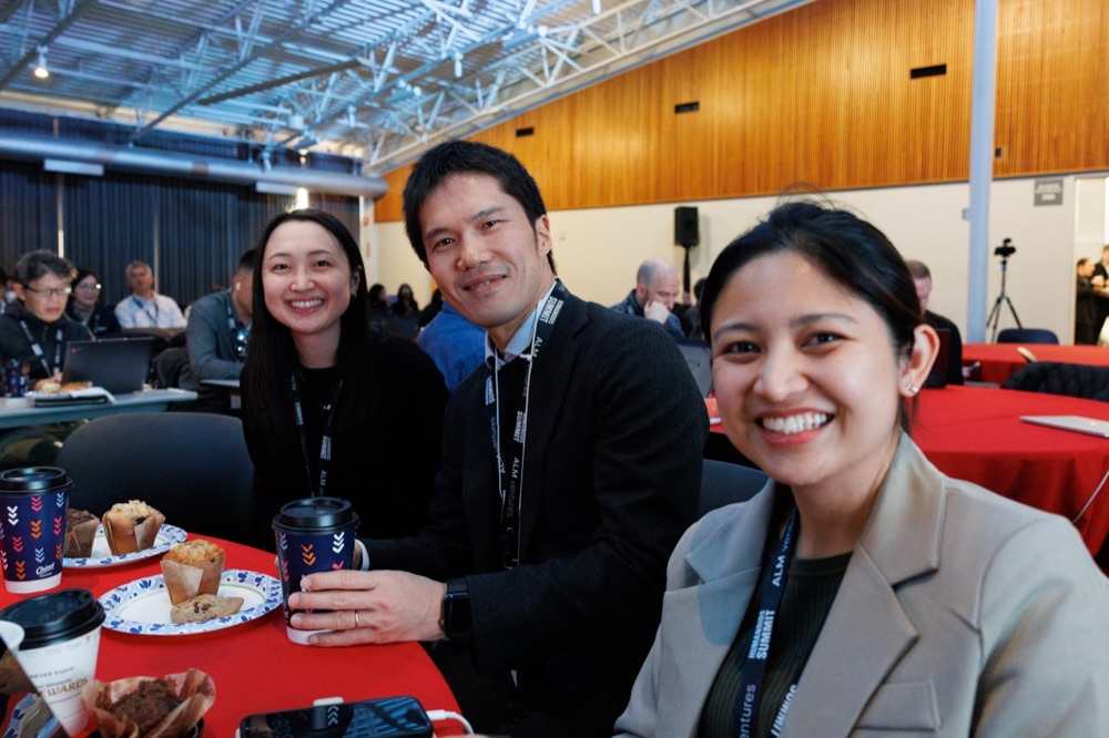 Three attendees smiling at a lunch table