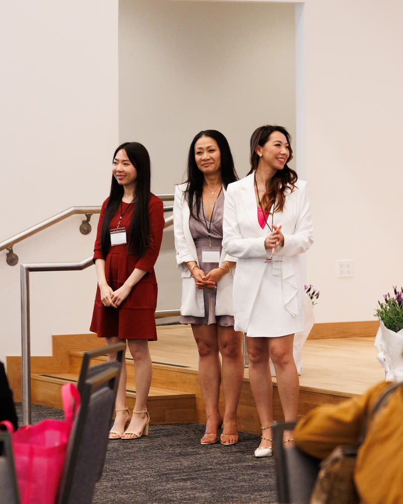 Three speakers standing together at the front of the room
