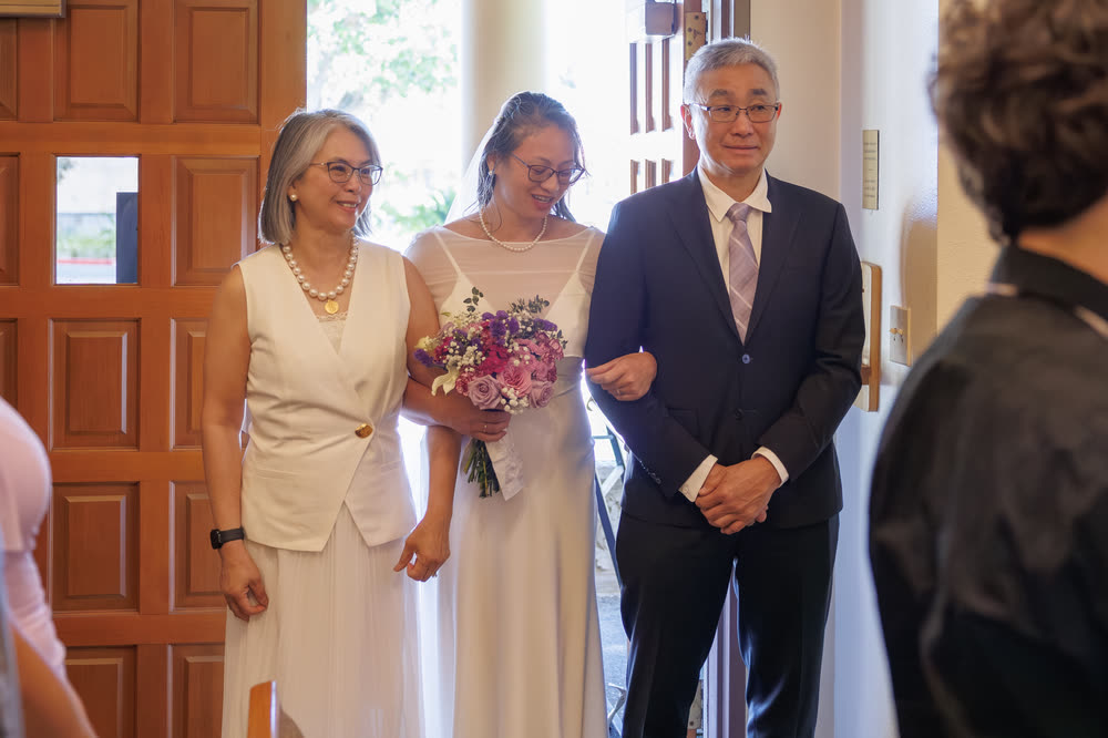 A bride walking into the church between her parents